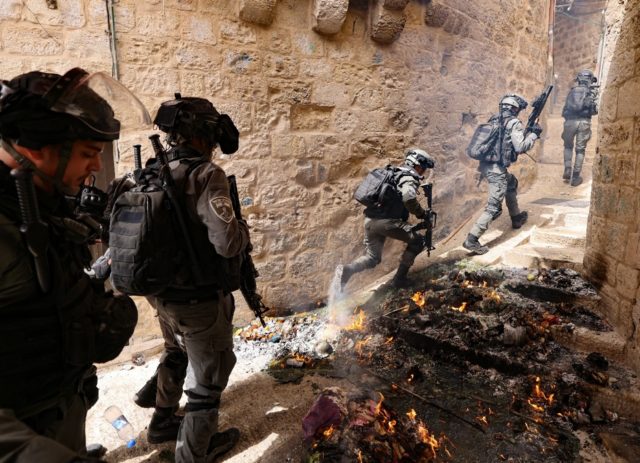 Israeli police pursue Palestinian protesters near Lion's Gate in Jerusalem's Old City on S