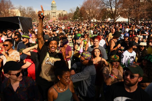 People dance and smoke during the Mile High 420 Festival in Denver, Colorado on April 20,