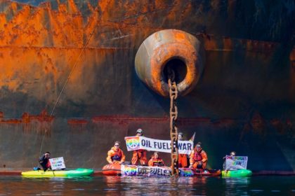 Greenpeace activists in a small boat chained themselves to the ship, while others in kayak
