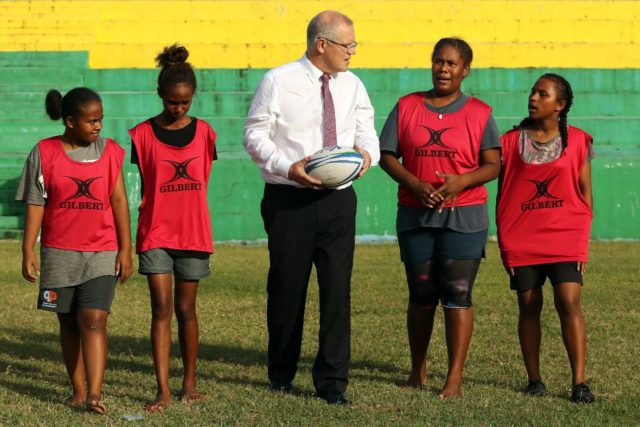 Australian Prime Minister Scott Morrison plays rugby with children in the Solomon Islands