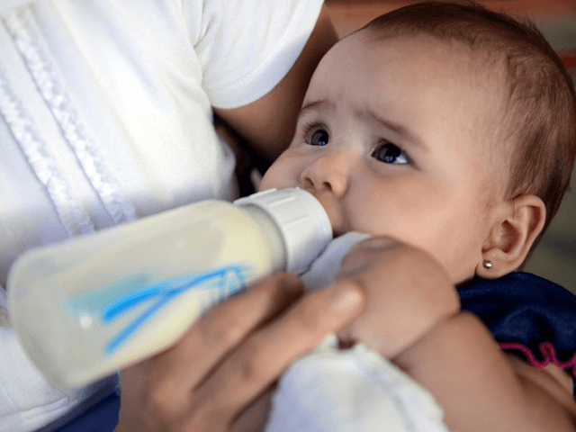 A woman feeds her baby with a bottle in Caracas on June 18, 2013. The congress would debate about the use of feeding bottle trying to encourage breastfeeding as a way to look after children healt. AFP PHOTO/LEO RAMIREZ (Photo credit should read LEO RAMIREZ/AFP via Getty Images)