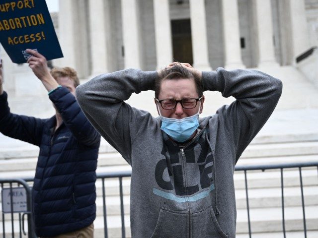 Jessica Golibart cries as demonstrators gather in front of the US Supreme Court in Washing