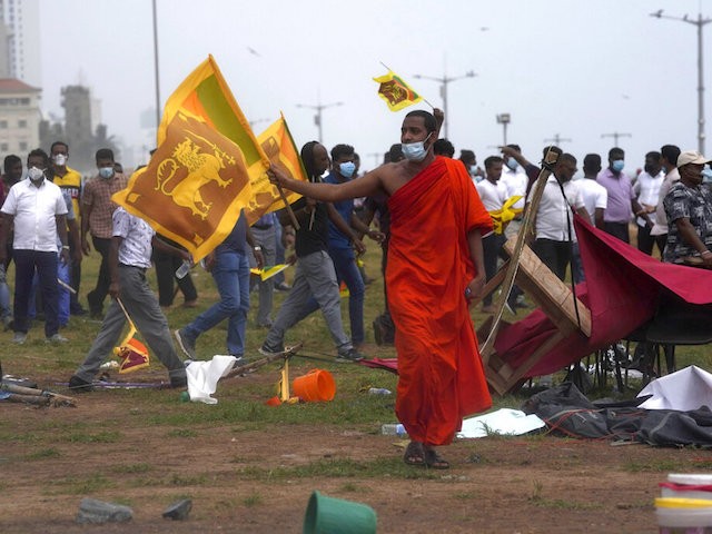 Sri Lanka???s pro government Buddhist monk with others vandalise the camp of anti government protestors outside the president???s office in Colombo, Sri Lanka, Monday, May 9, 2022. Government supporters on Monday attacked protesters who have been camped outside the office of Sri Lanka's prime minster, as trade unions began a "Week of Protests" demanding the government change and its president to step down over the country's worst economic crisis in memory.(AP Photo/Eranga Jayawardena)