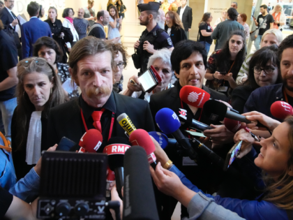 Eagles of Death Metal singer Jesse Hughes, center, and guitarist Eden Galindo, center right, answer reporters outside the special court room, Tuesday, May 17, 2022 in Paris. Performers from rock band Eagles of Death Metal are appearing in a Paris court to testify about the night Islamic State extremists stormed …