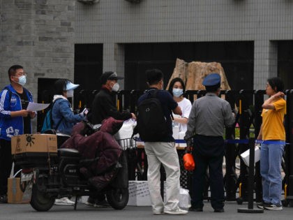 Couriers pass over their deliveries at one of the entrance to the main campus of Peking University on Tuesday, May 17, 2022, in Beijing. Administrators at the elite Beijing university have backed down from plans to further tighten pandemic restrictions on students as part of China’s “zero-COVID” strategy after a …