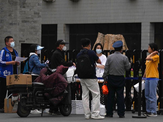 Couriers pass over their deliveries at one of the entrance to the main campus of Peking Un