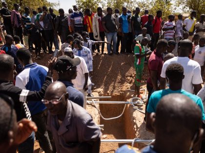 People, who are angry about the organisation of the burial and the sate of the graves in the military section at Gounghin Cemetery in Ouagadougou, attend the burial, on November 23, 2021 of Burkinabe soldiers killed in the attack on a gendarmerie camp at Inata on November 14, 2021. (Photo …