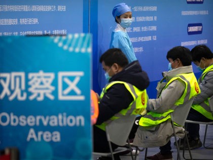 A medical worker wearing protective equipment monitors patients after they received the coronavirus vaccine at a vaccination facility in Beijing, Friday, Jan. 15, 2021. A city in northern China is building a 3,000-unit quarantine facility to deal with an anticipated overflow of patients as COVID-19 cases rise ahead of the …