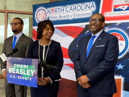Democratic U.S. Senate candidate Cheri Beasley, center, laughs with husband Curtis Owens, right, while son Matthew Owens, watches, before she speaks with reporters at the North Carolina State Fairgrounds in Raleigh, N.C., on Thursday, Feb. 24, 2022. Beasley filed her candidacy papers with the board at the fairgrounds after filing …
