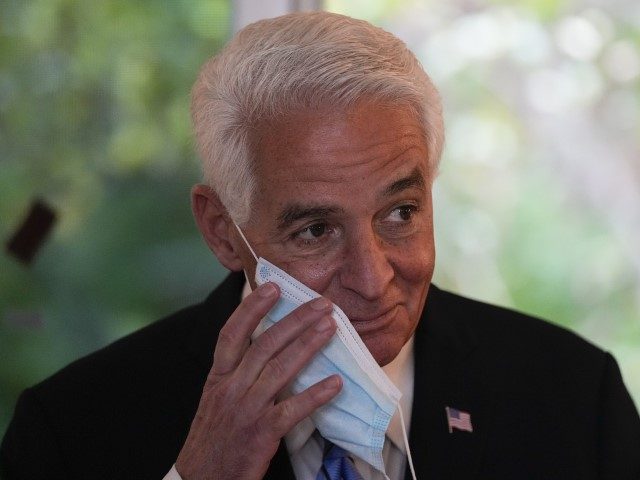 U.S. Rep. Charlie Crist (D-FL) removes his mask to speak at a press conference to announce