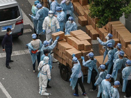 Workers wearing protective gear stack up boxes with food over a cart to deliver in a neighborhood during a Covid-19 coronavirus lockdown in the Jing'an district in Shanghai on May 7, 2022. (Photo by Hector RETAMAL / AFP) (Photo by HECTOR RETAMAL/AFP via Getty Images)