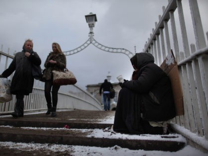 DUBLIN, IRELAND - DECEMBER 01: A homeless woman holds out a cup for money on The Ha'Penny Bridge on December 1, 2010 in Dublin, Ireland. The Irish economy has faltered after years of growth and recently European Union finance ministers approved an aid package totalling 85-billion Euros (113 billion U.S. …