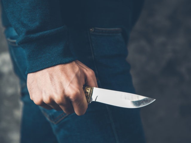 man hand holding knife on abstract background