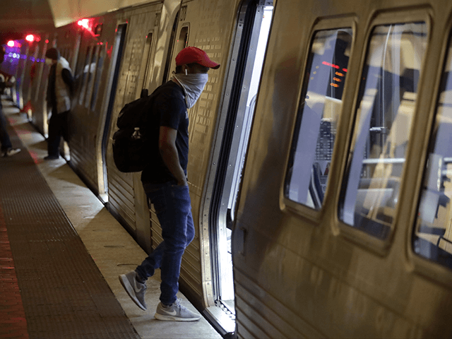 A passenger wears a mask as he enters a Metro train car at Metro Center Station April 7, 2