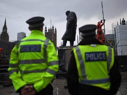 LONDON, ENGLAND - JUNE 17: Police look on as workers uncover the statue of Winston Churchill in Parliament Square on June 17, 2020 in London, England. The statue was covered up to protect it from vandalism over the weekend, after it was targeted by Black Lives Matter protesters. It is …