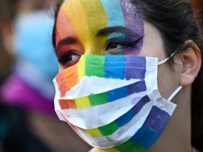 A protestor wearing a face mask and face paint in the colours of the rainbow flag takes part in a demonstration in support of the bioethics bill on Medically Assisted Reproduction (PMA - Procreation Medicalement Assistee), in Rennes, western France on October 10, 2020. - Voted on August 1 in …