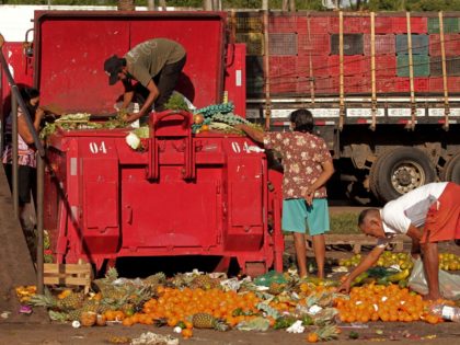 People collect fruits and vegetables discarded by street vendors in Belem, Para state on November 4, 2021. - According to the Brazilian government, approximately 19 million people in Brazil have gone hungry over the past year, almost twice the 10 million who did so in 2018. Approximately 55 percent of …