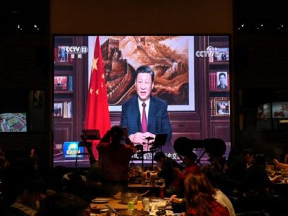 People have their dinner at a restaurant as a screen broadcasts Chinese President Xi Jinping delivering his New Year speech in Beijing on December 31, 2021. (Photo by JADE GAO / AFP) (Photo by JADE GAO/AFP via Getty Images)