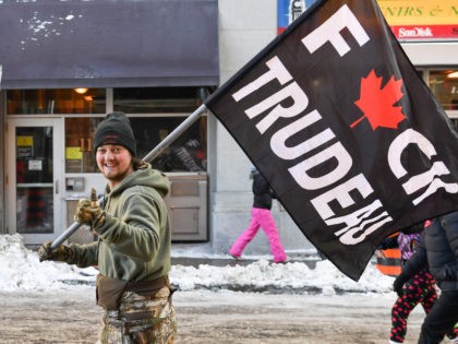 OTTAWA, ON - FEBRUARY 05: (EDITORS NOTE: Image contains profanity.) A protester holds up a flag showing his displeasure with the mandates imposed by the Prime Minister of Canada Justin Trudeau during the Freedom Convoy truck protest on February 5, 2022 in Ottawa, Canada. Truckers continue their rally over the …