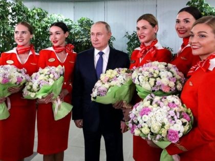 Russian President Vladimir Putin (C) poses for photo with Aeroflot employees during his visit to Aeroflot aviation training complex outside Moscow on March 5, 2022. - Russian President Vladimir Putin said Saturday that any country that sought to impose a no-fly zone over Ukraine would be considered by Moscow to …