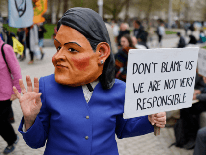 An activist from the climate change protest group Extinction Rebellion (XR), dressed up as Britain's Home Secretary Priti Patel takes part in a demonstration outside the headquarters of the Royal Dutch Shell, a multinational oil and gas company, in central London on April 13, 2022, as part of a series …