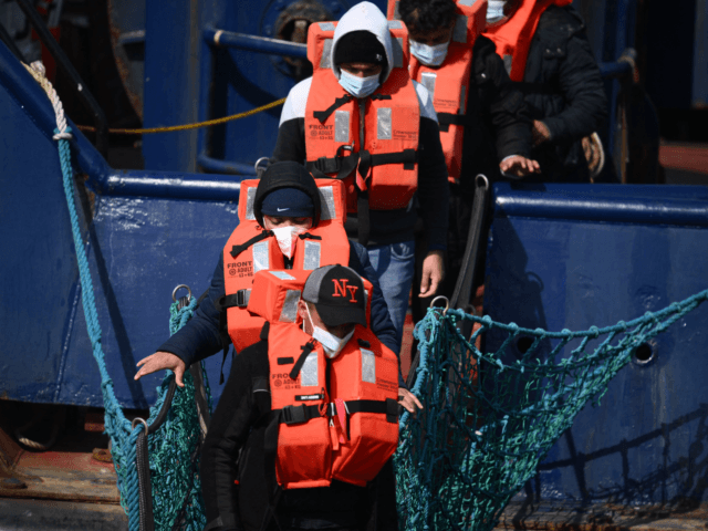 A group of migrants disembark from a UK Border Force boat at the port of Dover having bein