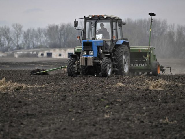 A farmer drives his tractor as he sows oats in a field east of Kyiv on April 16, 2022. - Russia invaded Ukraine on February 24, 2022. (Photo by Genya SAVILOV / AFP) (Photo by GENYA SAVILOV/AFP via Getty Images)