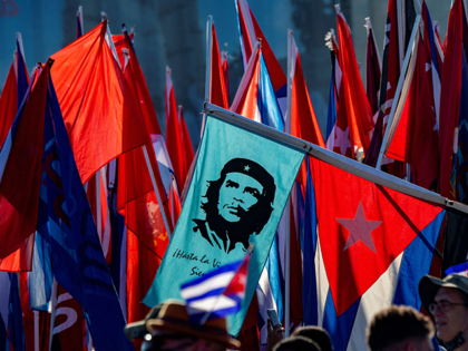A demonstrator carries a banner with an image of late Argentine-born Marxist revolutionary hero Ernesto "Che" Guevara during the commemoration of May Day (Labour Day) to mark the international day of the workers, at Havana's Revolution Square, on May 1, 2022. (Photo by Yamil LAGE / AFP) (Photo by YAMIL …
