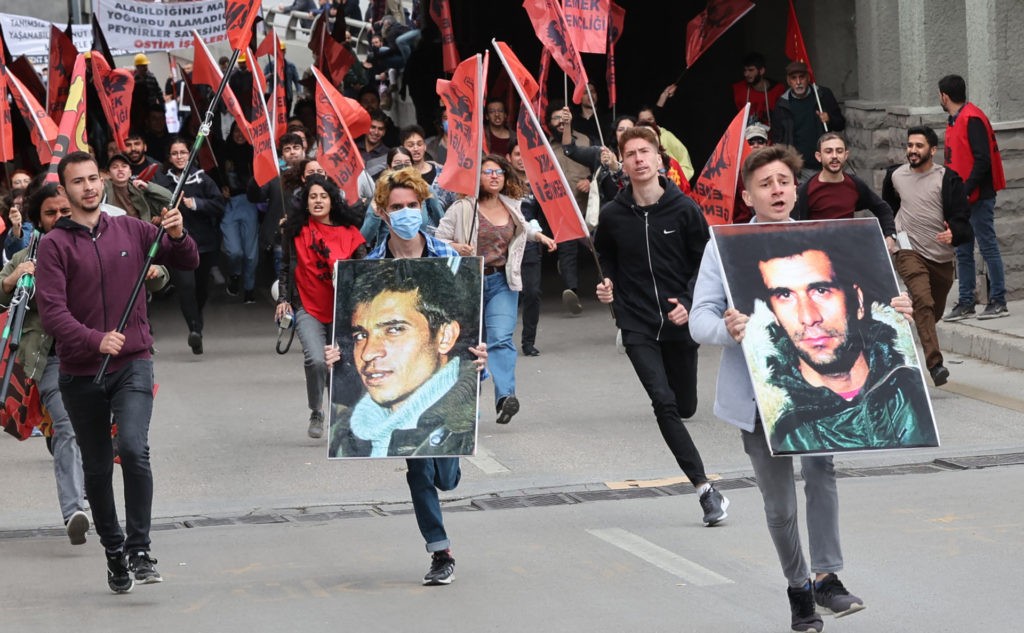 Protesters run with portraits of Deniz Gezmis (R) and Yusuf Aslan (L), Turkish revolutionaries from 68 movement in Turkey, during the annual May Day (Labour Day) demonstration marking the international day of the workers in Ankara, on May 1, 2022. (Photo by Adem ALTAN / AFP) (Photo by ADEM ALTAN/AFP via Getty Images)