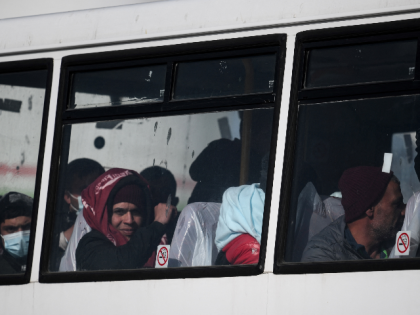 Migrants picked up at sea while attempting to cross the English Channel from France, look on from bus driving them to a processing center, after disembarking from a UK Border Force boat, in the Marina at the Dover port, on May 3, 2022, in Dover, on the south-east coast of …