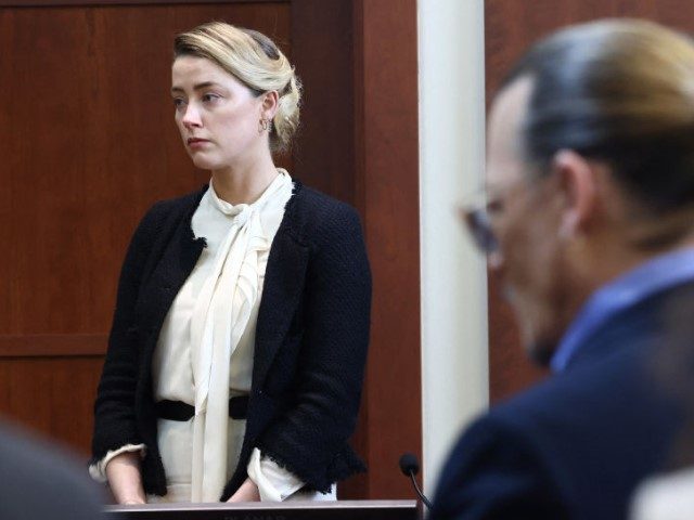 US actress Amber Heard (L) testifies as US actor Johnny Depp looks on during a defamation