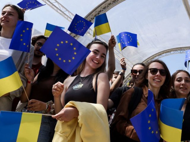 People wave Ukrainian and European flags during an Europe Day Ceremony in support of Ukrai