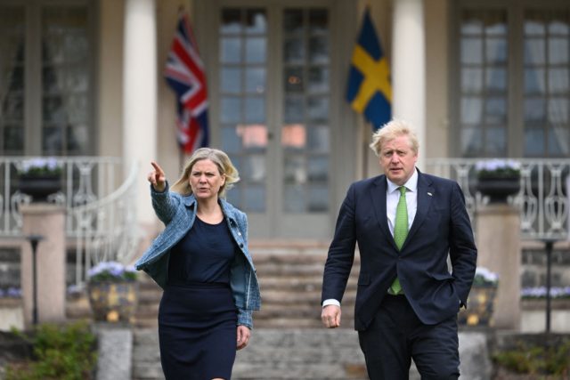 Sweden's Prime Minister Magdalena Andersson shows the way to British Prime Minister Boris