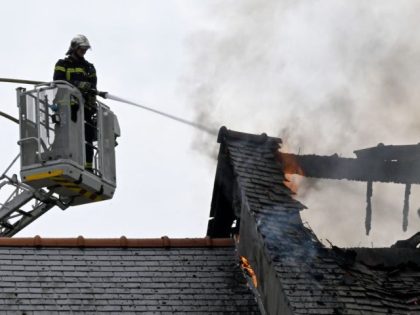 A firefighter works to extinguish a fire in a house in Saint-Symphorien, western France, on May, 22 2022. - The fire caused no casualties. (Photo by Damien MEYER / AFP) (Photo by DAMIEN MEYER/AFP via Getty Images)