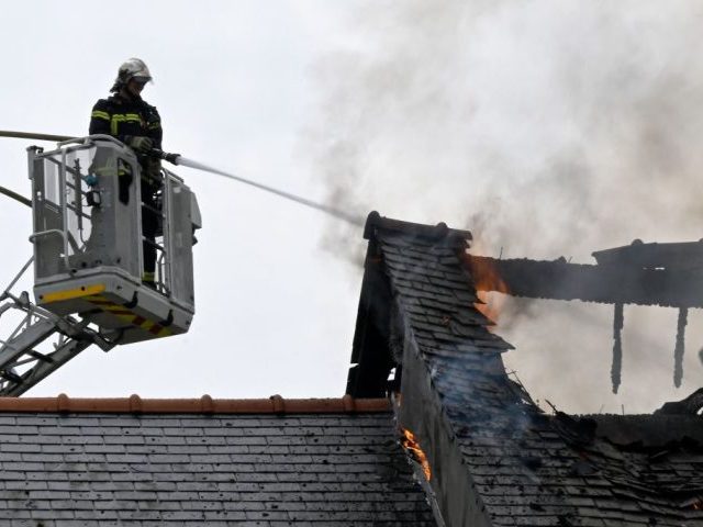 A firefighter works to extinguish a fire in a house in Saint-Symphorien, western France, o