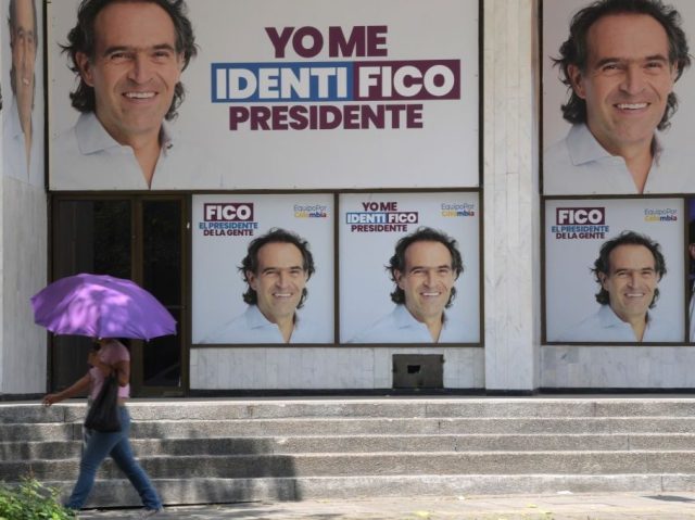 A woman walks near propaganda of Colombian presidential candidate for the Equipo Colombia coalition, Federico Gutierrez, in Cali, Colombia, on May 24, 2022. - Colombia will hold presidential elections on May 29. (Photo by Raul ARBOLEDA / AFP) (Photo by RAUL ARBOLEDA/AFP via Getty Images)