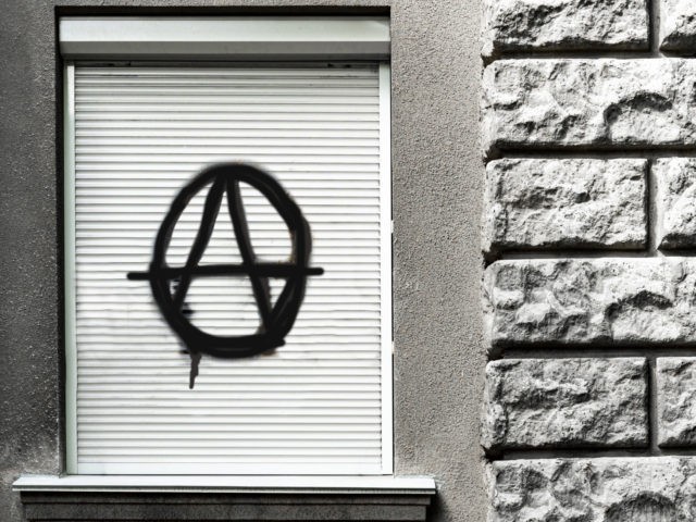 black sign of anarchy on closed window. culture of anarchists, punks and street protests.