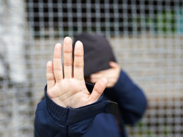 woman behind the fence, close-up of a refugee woman's hand