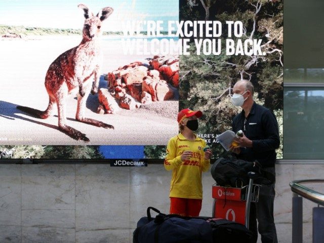 A young surf life saver hands out gifts to an arriving passenger at Sydney Airport on February 21, 2022 in Sydney, Australia. Australia is welcoming fully-vaccinated international travellers for the first time since closing its borders to all non-citizens and non-residents in the effort to limit the spread of COVID-19 …