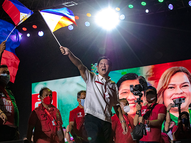 Ferdinand "Bongbong" Marcos Jr. waves a Philippine flag during his last campaign rally bef