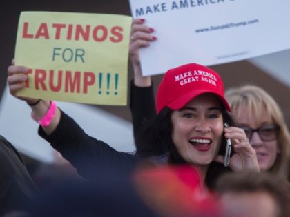 A woman hoods a sign expressing Latino support for Republican presidential candidate Donal