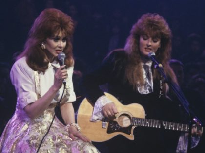 Naomi (left) and daughter Wynonna perform on stage as The Judds in 1989. (Photo by David Redfern/Redferns)