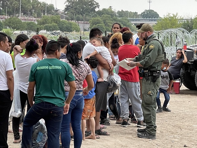 An Eagle Pass Station Border Patrol agent attempts to keep up with processing a large surge of migrants crossing the Rio Grande into Texas. (Randy Clark/Breitbart Texas)