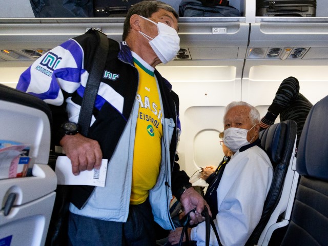 Passengers wear protective face masks in a airplane before take-off at the Phoenix International Airport on March 14, 2020 in Phoenix, Arizona. Passengers are wearing masks to avoid the spread of the coronavirus (COVID-19). (Coelho/Getty Images)