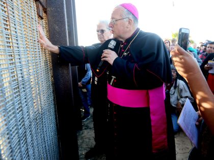 Robert W. McElroy, Archbishop of San Diego speaks with participants through the fence during the 23rd Posada Sin Fronteras where worshipers gather on both sides of the US-Mexican border fence for a Christmas celebration, at Friendship Park and Playas de Tijuana in San Ysidro, California on December 10, 2016. / …
