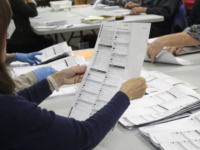 An election worker examines a ballot at the Clackamas County Elections office on Thursday,