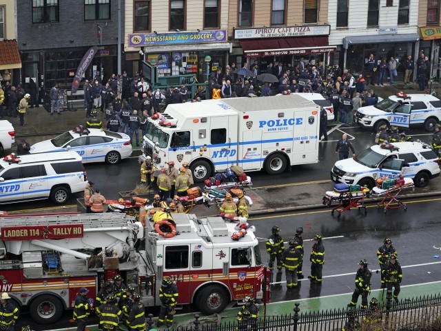 Emergency personnel gather at the entrance to a subway stop in the Brooklyn borough of New York, Tuesday, April 12, 2022. Multiple people were shot and injured Tuesday at a subway station in New York City during a morning rush hour attack that left wounded commuters bleeding on a train platform. (John Minchillo/AP)