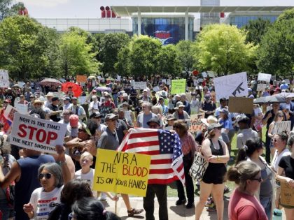 Protesters hold a rally at Discovery Green Park, across the street from the National Rifle Association Annual Meeting held at the George R. Brown Convention Center Friday, May 27, 2022, in Houston. (AP Photo/Michael Wyke)