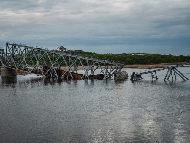 This photograph taken on April 29, 2022, shows a destroyed railway bridge, over the Siverskyi Donets river, in Raygorodok, eastern Ukraine, amid the Russian invasion of Ukraine. (YASUYOSHI CHIBA/AFP via Getty Images)