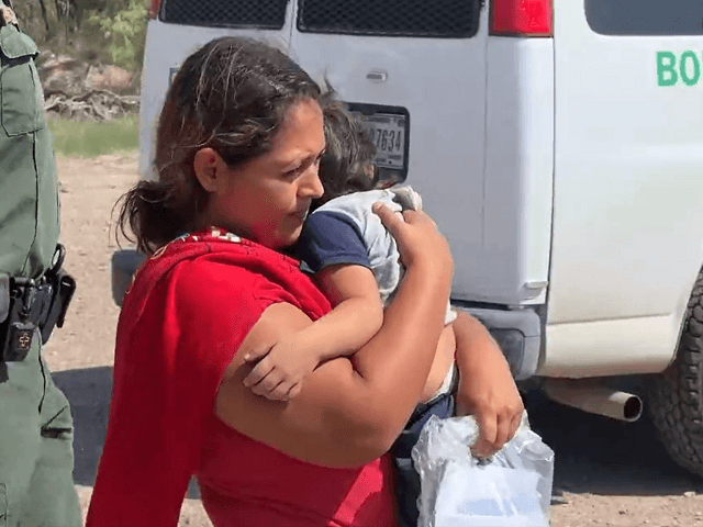 A migrant woman carries a two-year-old girl after human smugglers directed her to take the child across the Rio Grande into Texas. (Fox News Video Screenshot)